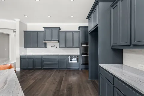 a kitchen with kitchen island granite countertop wooden cabinets and a granite counter tops