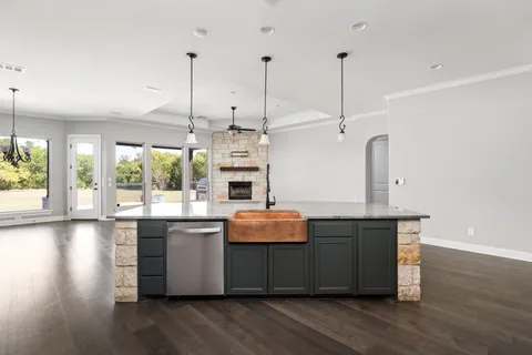 a kitchen with stainless steel appliances granite countertop wooden floors and sink