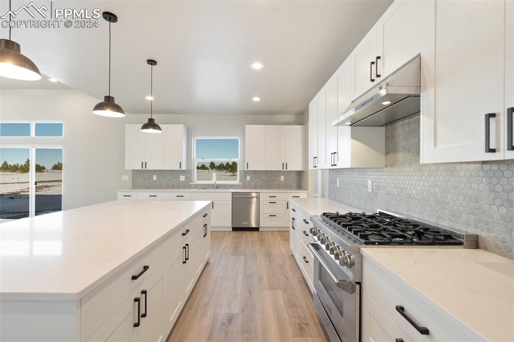 17615 Blacksmith Drive Peyton, CO 80831 - Photo 14 of 41 a kitchen with white cabinets a sink stove and white cabinets