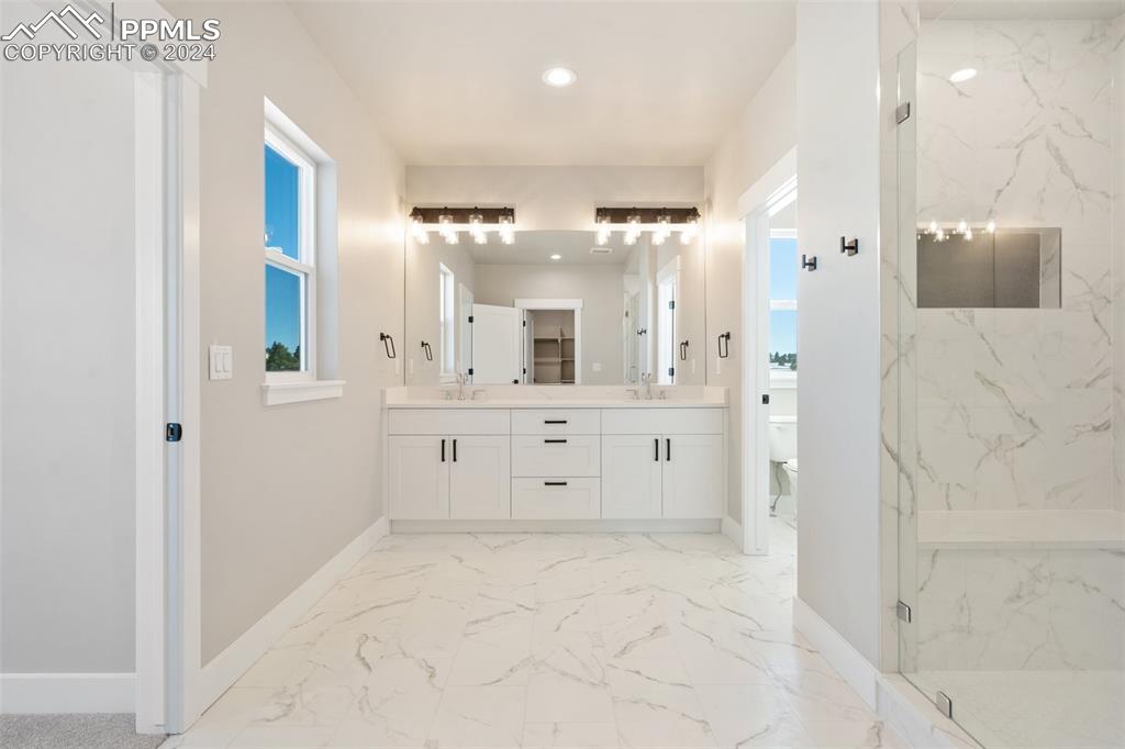 17615 Blacksmith Drive Peyton, CO 80831 - Photo 21 of 41 a bathroom with a double vanity sink mirror and shower