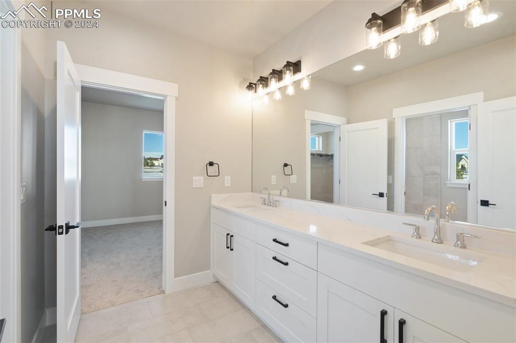 17615 Blacksmith Drive Peyton, CO 80831 - Photo 30 of 41 a bathroom with a double vanity sink a mirror and a shower