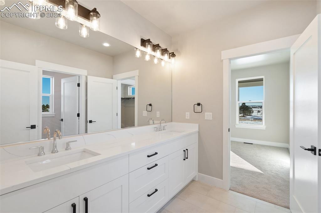 17615 Blacksmith Drive Peyton, CO 80831 - Photo 31 of 41 a bathroom with a double vanity sink and a mirror