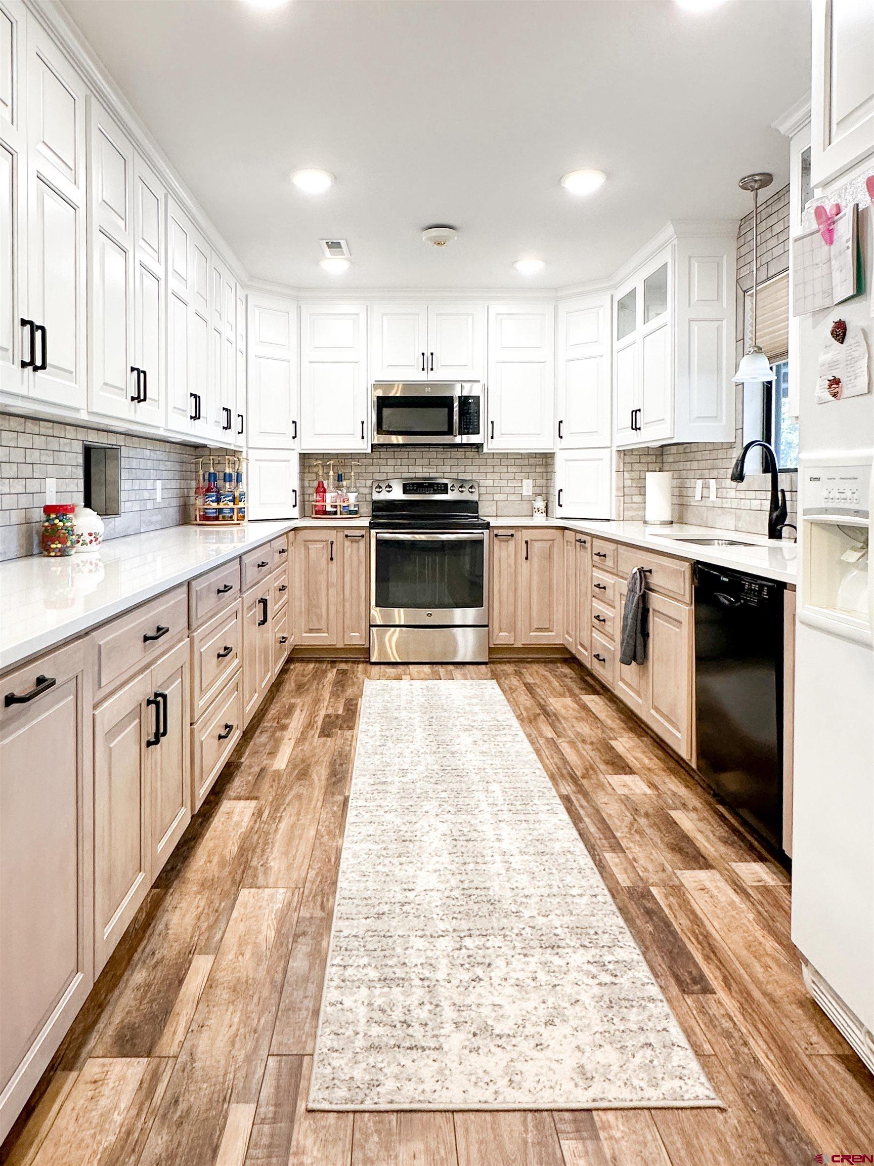 18555 F Road Delta, CO 81416 - Photo 11 of 43 a kitchen with granite countertop a stove top oven sink and cabinets
