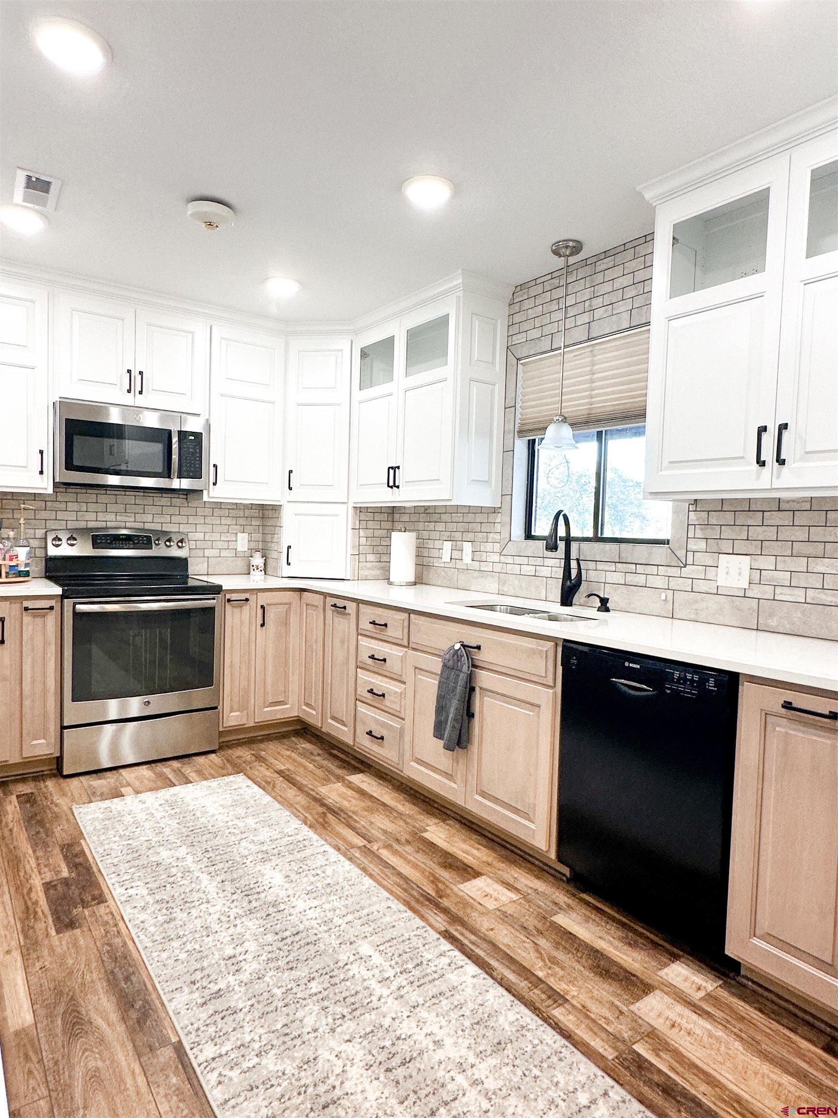 18555 F Road Delta, CO 81416 - Photo 13 of 43 a large kitchen with stainless steel appliances granite countertop a stove granite counter tops and a sink