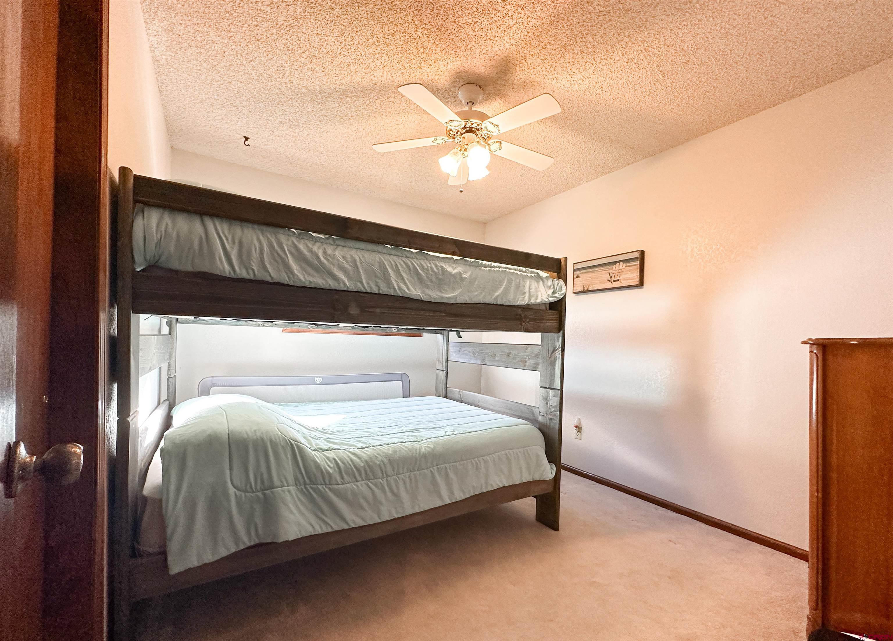 18555 F Road Delta, CO 81416 - Photo 19 of 43 a bedroom with a bed and a chandelier