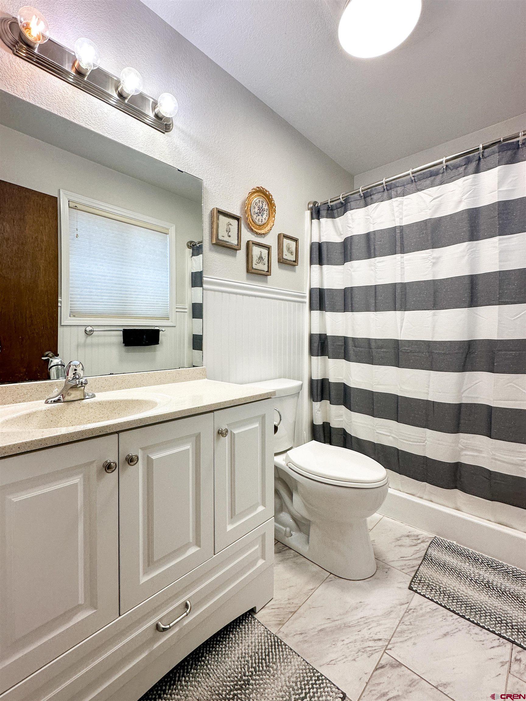 18555 F Road Delta, CO 81416 - Photo 24 of 43 a bathroom with a sink a toilet a mirror and shower curtain