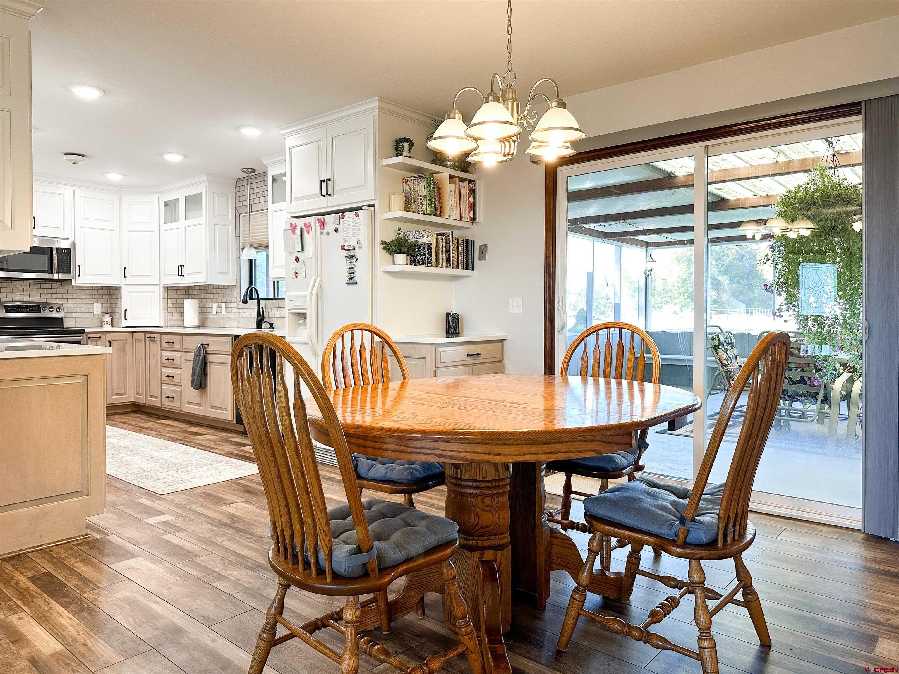 18555 F Road Delta, CO 81416 - Photo 10 of 43 a dining room with furniture a chandelier and wooden floor