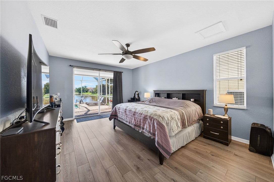 8313 Sumner Avenue Fort Myers, FL 33908 - Photo 17 of 42 a bed room with a bed and a flat tv screen on a dresser