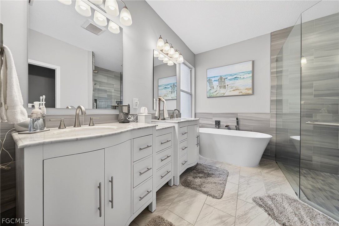 8313 Sumner Avenue Fort Myers, FL 33908 - Photo 20 of 42 a bathroom with a double vanity sink mirror and bathtub