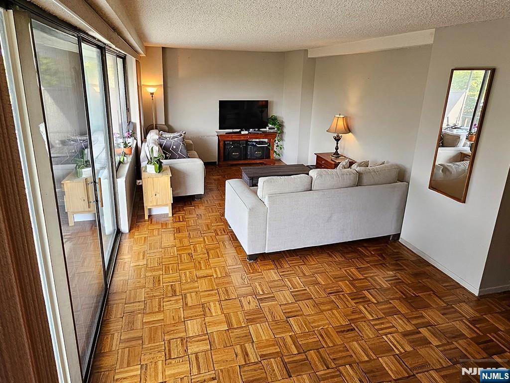 277 Prospect Avenue, Unit 4H Hackensack, NJ 07601 - Photo 12 of 19 a living room with furniture and a flat screen tv
