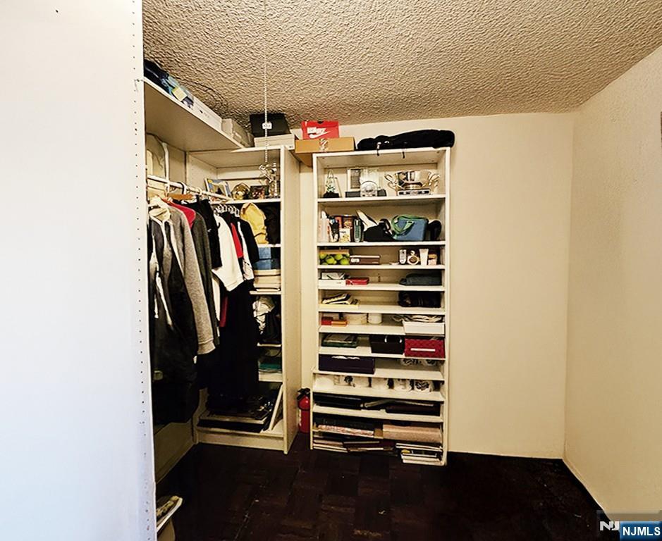 277 Prospect Avenue, Unit 4H Hackensack, NJ 07601 - Photo 5 of 19 a view of walk in closet with clothes and shoes