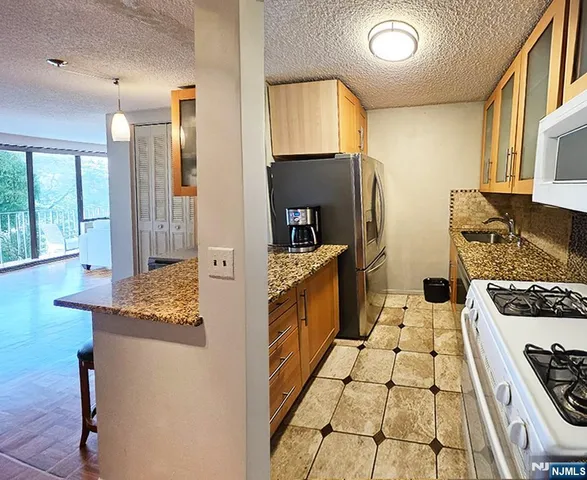 a kitchen with a stove a refrigerator and a sink
