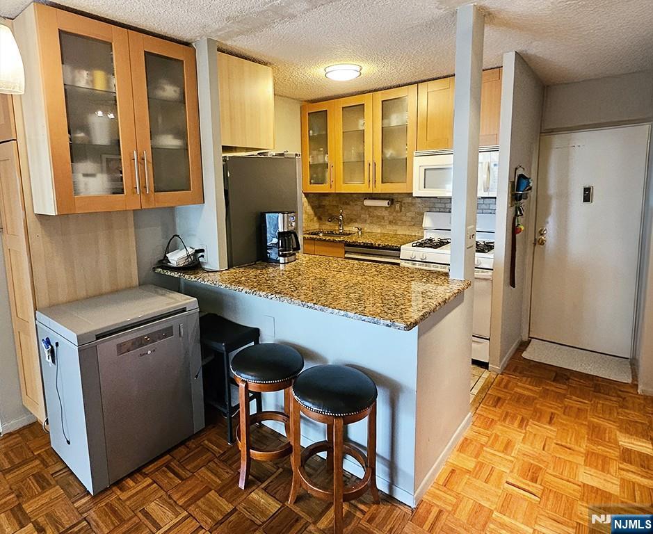277 Prospect Avenue, Unit 4H Hackensack, NJ 07601 - Photo 7 of 19 a kitchen with a stove a refrigerator and a sink