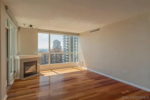 wooden floor fireplace and windows in an empty room