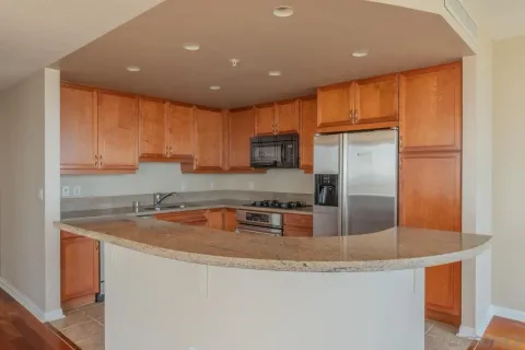a kitchen with granite countertop a sink a counter top stainless steel appliances and cabinets