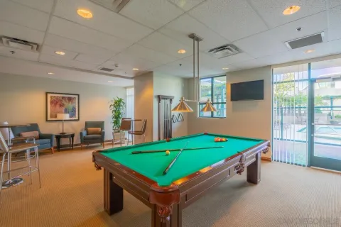 a room with pool table and windows