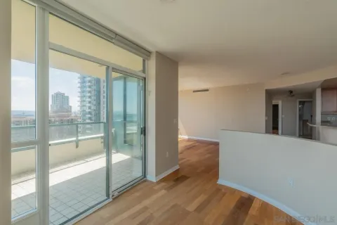 a view of hallway with a large window and wooden floor