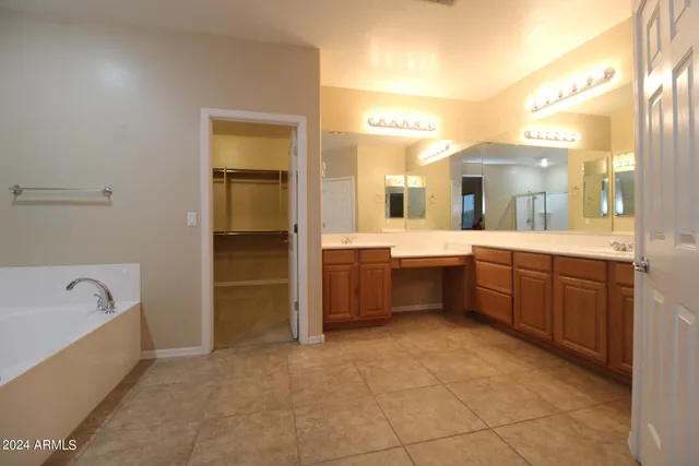 a bathroom with a tub sink and mirror
