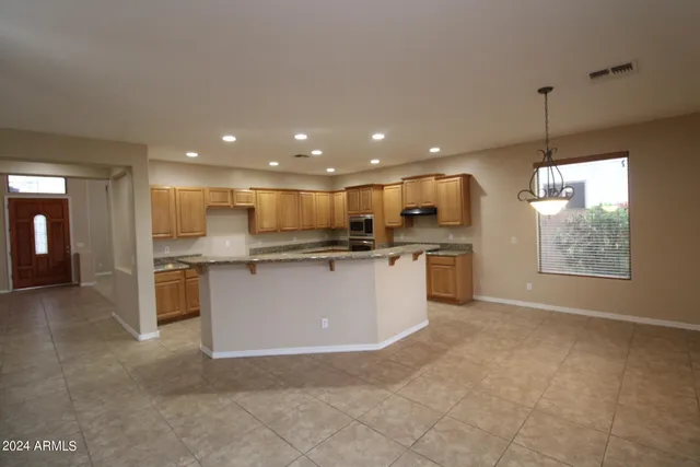 a view of kitchen with kitchen island stainless steel appliances refrigerator stove microwave and cabinets