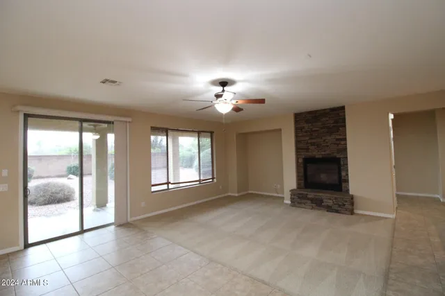 a view of an empty room with a fireplace and a window