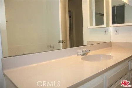 a bathroom with a granite countertop sink and a bathtub