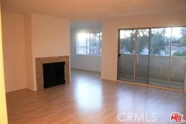 an empty room with wooden floor and a fireplace