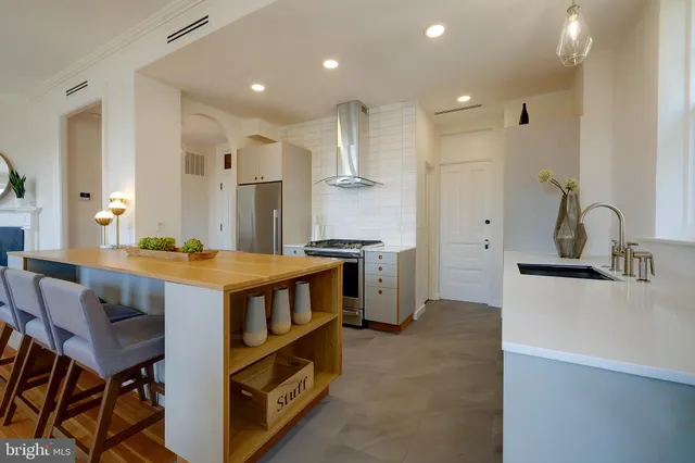 a kitchen with stainless steel appliances granite countertop a sink and a refrigerator