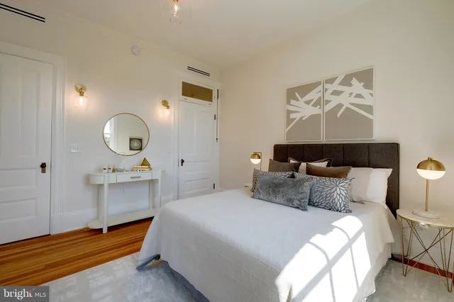 a bedroom with bed and wooden floor