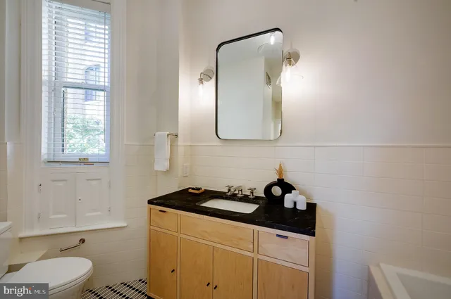 a bathroom with a sink a toilet and a mirror