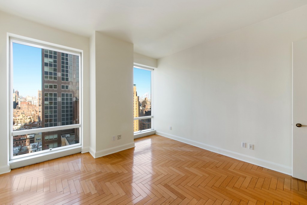 845 United Nations Plaza, Unit 15A Manhattan, NY 10017 - Photo 5 of 8 an empty room with wooden floor and windows