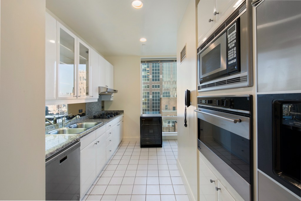 845 United Nations Plaza, Unit 15A Manhattan, NY 10017 - Photo 6 of 8 a kitchen with a sink stove and cabinets
