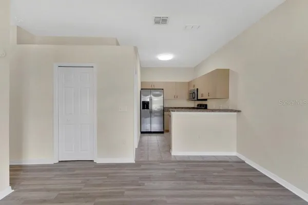 a view of kitchen view wooden floor and white cabinets