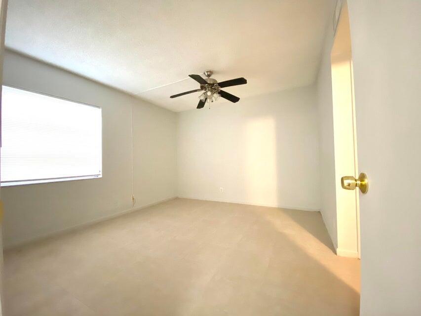626 Northwest 13th Street, Unit 16 Boca Raton, FL 33486 - Photo 7 of 10 an empty room with a window and a ceiling fan