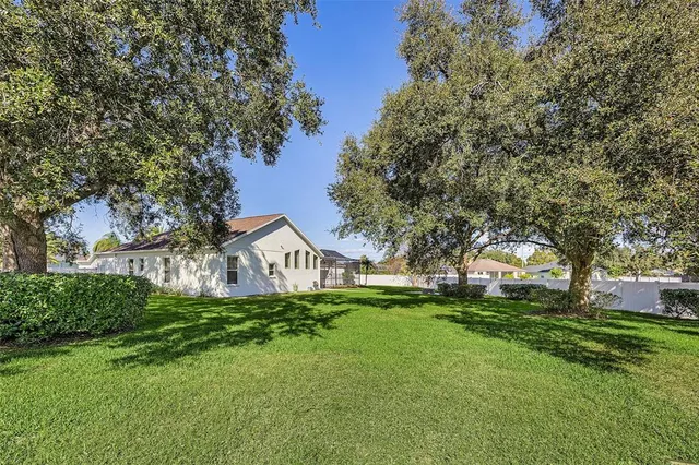 an aerial view of a house with outdoor seating and trees