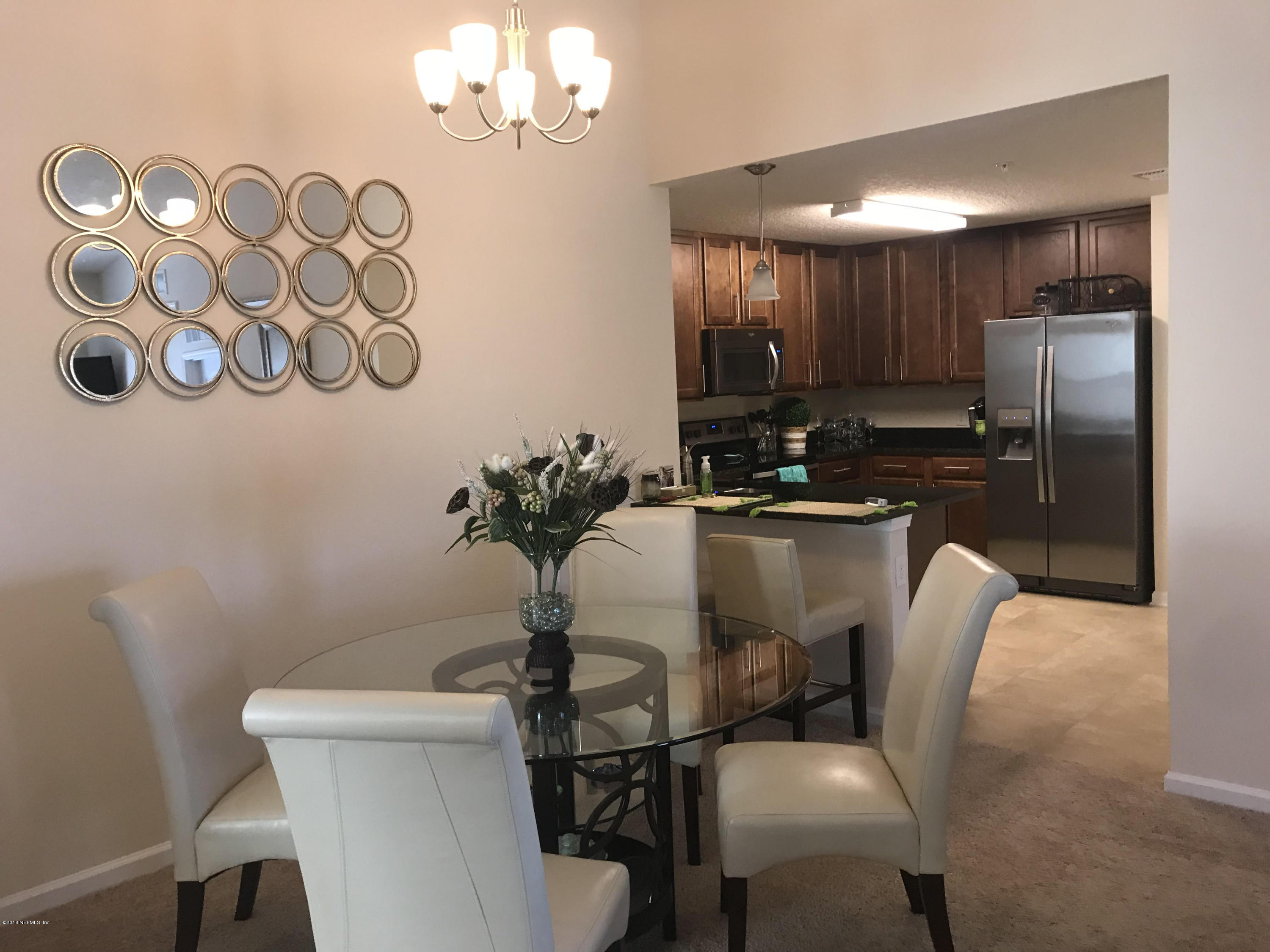 218 Larkin Place, Unit 111 St. Johns, FL 32259 - Photo 4 of 21 a dining room with furniture a chandelier and wooden floor
