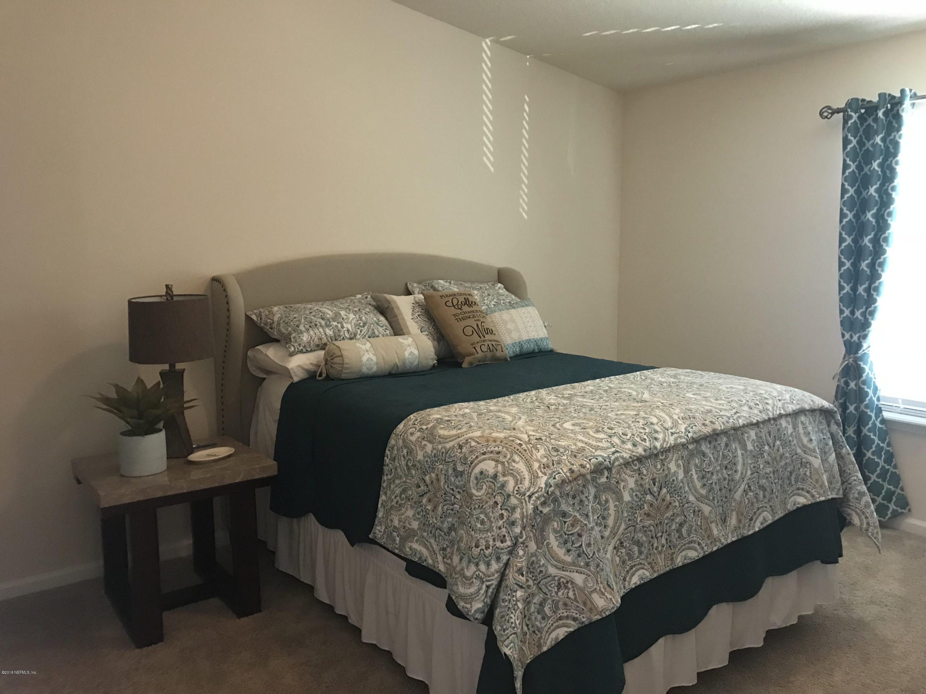 218 Larkin Place, Unit 111 St. Johns, FL 32259 - Photo 8 of 21 a bed sitting in a bedroom next to a window