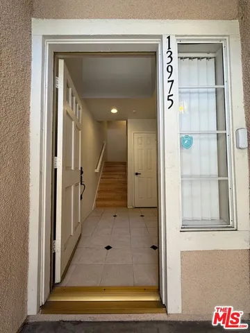 a view of a hallway with a door and stairs