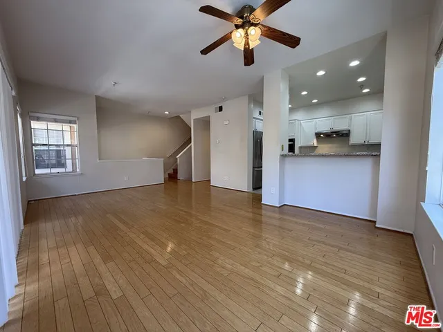 a view of an empty room with window and wooden floor