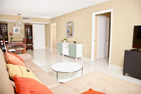 a living room with furniture a flat screen tv and a table