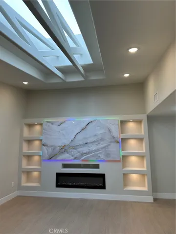 an empty room with large windows and a ceiling fan