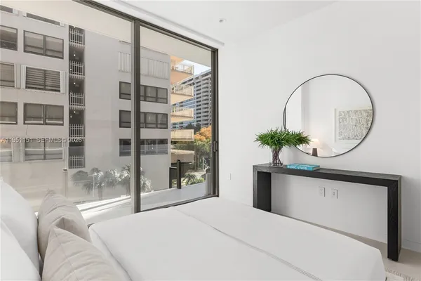 a bedroom with a bed and a large window