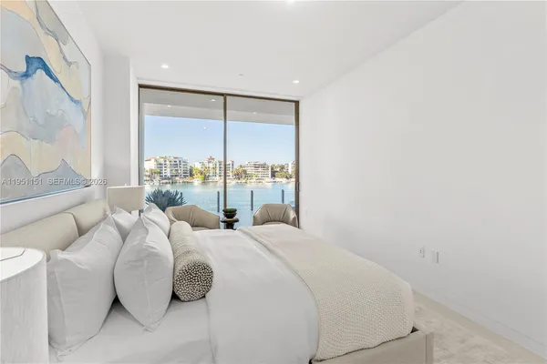 a bedroom with a large bed and a potted plant