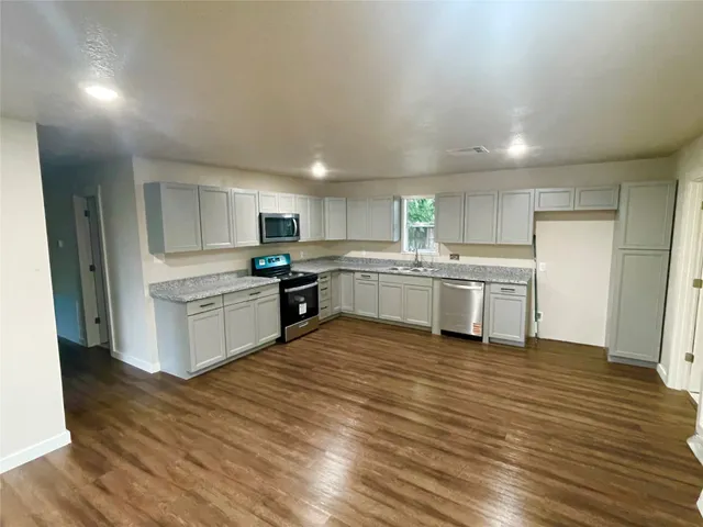 a kitchen with white cabinets and white appliances