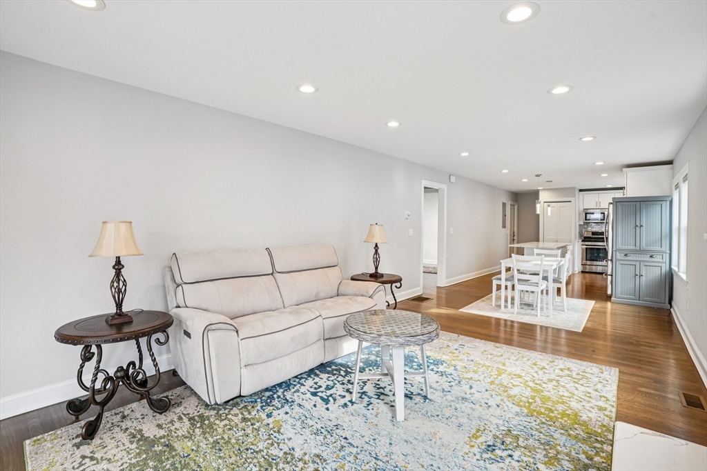 33 Slade Street, Unit 1 Belmont, MA 02478 - Photo 7 of 26 a living room with furniture and a dining table with wooden floor