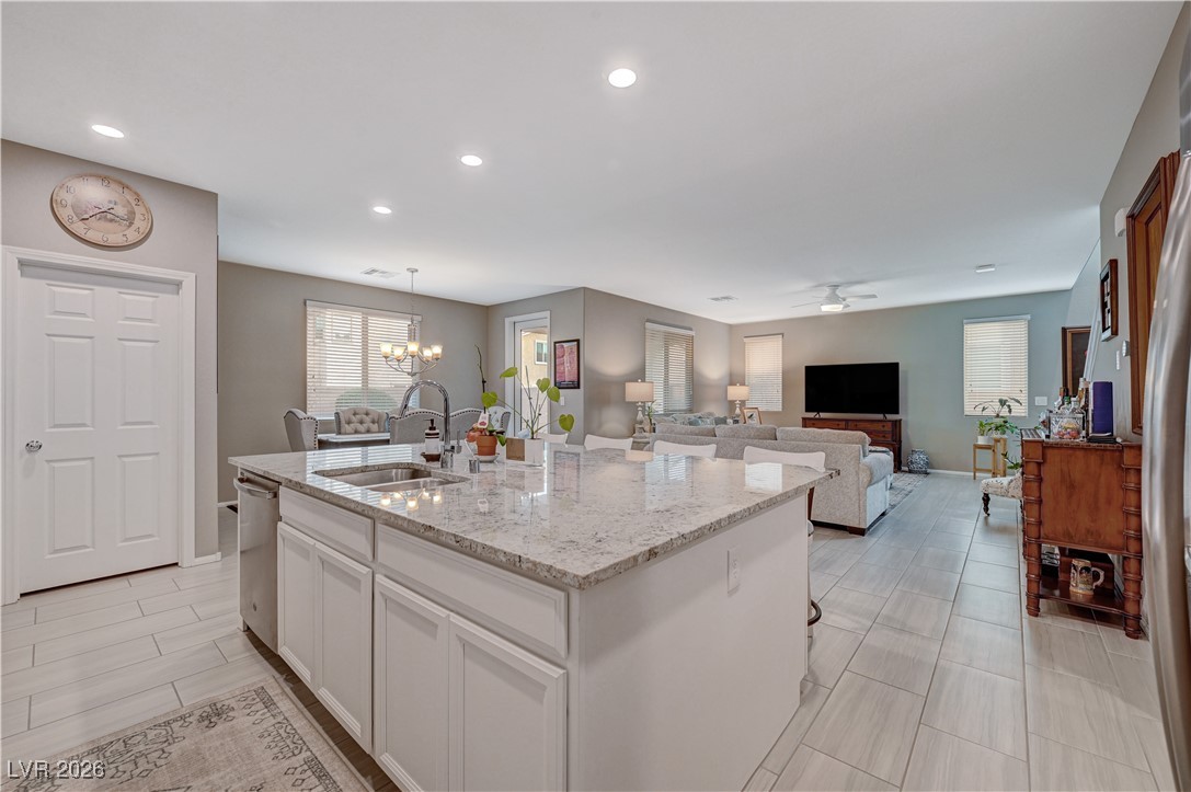 3826 Asia Road North Las Vegas, NV 89032 - Photo 30 of 30 Kitchen with white cabinetry, light stone countertops, open floor plan, and a kitchen island with sink