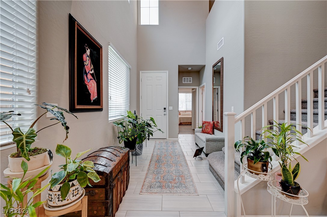 3826 Asia Road North Las Vegas, NV 89032 - Photo 12 of 30 Foyer with light tile wood grain-like porcelain tile floors and a towering ceiling
