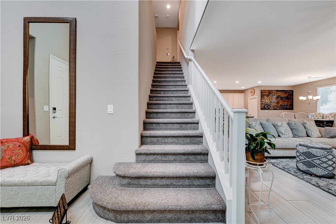 3826 Asia Road North Las Vegas, NV 89032 - Photo 16 of 30 Staircase with light carpet and upgraded wooden banister