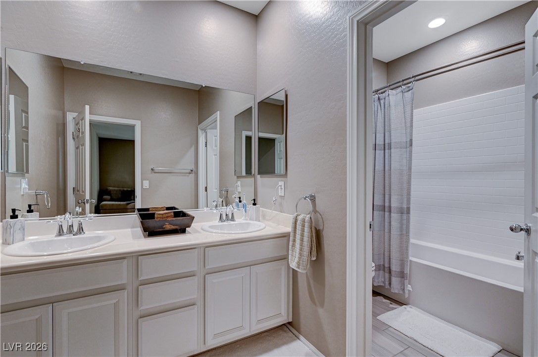 3826 Asia Road North Las Vegas, NV 89032 - Photo 25 of 30 Full upstairs bathroom with double vanity, shower / tub combo with curtain, and a textured wall