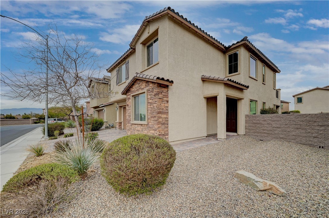 3826 Asia Road North Las Vegas, NV 89032 - Photo 3 of 30 View of home's exterior with stucco siding, a tiled roof, and stone facade