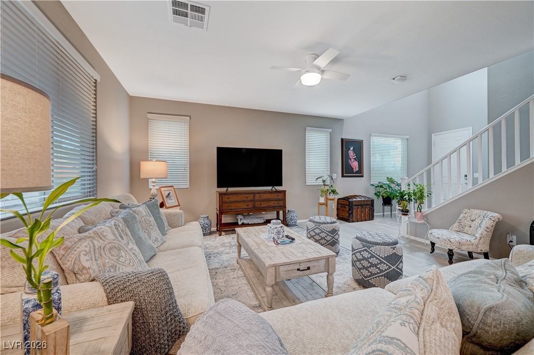 3826 Asia Road North Las Vegas, NV 89032 - Photo 7 of 30 Living room featuring ceiling fan, wood grain-like porcelain tile floors, plenty of natural light, and stairway